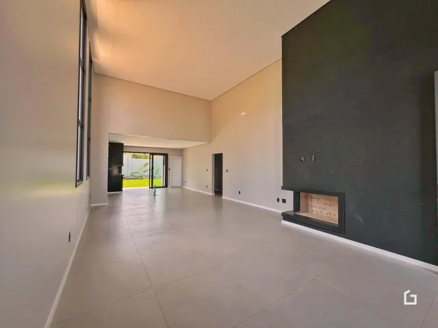 Vista de um corredor interno com piso de cerâmica e parede de destaque.