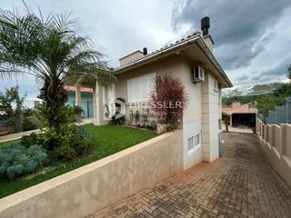 Fachada de uma residência em Lajeado com jardim e calçada de tijolos.