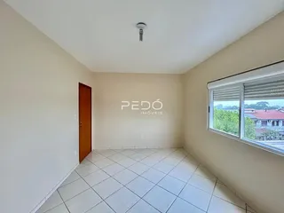 Ambiente interno de uma sala com piso de cerâmica e porta de madeira.