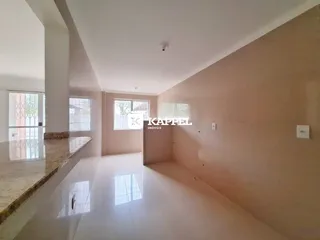 Vista de um corredor amplo com piso claro e grandes janelas em um imóvel em Lajeado.