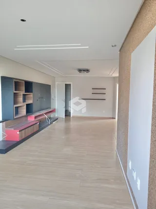 Hall de entrada com piso de madeira clara e estantes embutidas.