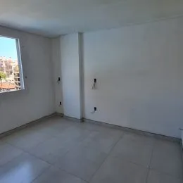 Foto de um ambiente interno com piso de cerâmica claro e paredes brancas.