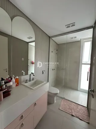 Banheiro moderno com bancada e box de vidro.