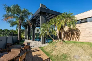 Fachada de uma residência com deck de madeira e jardim em Lajeado, Brasil.