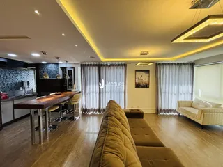 Sala de estar com mesa de jantar e sofá em um apartamento.