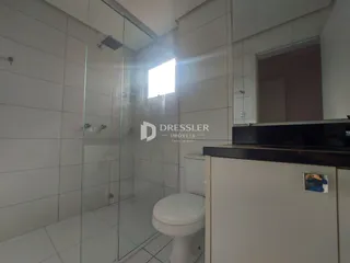 Foto de um banheiro com revestimento cerâmico e box de vidro.