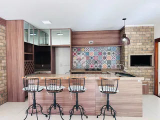 Cozinha moderna com ilha e revestimento de mosaico na residência.