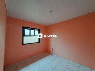 Foto de um cômodo interno com paredes cor de salmão e piso de cerâmica.