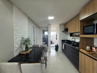 Interior de uma sala de estar com cozinha moderna em Lajeado.