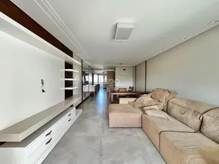 Corredor interno de uma residência moderna com estantes embutidas e sofá.