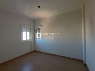 Foto de uma sala de estar com piso de madeira clara e paredes brancas.