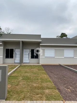 Fachada de uma residência em Lajeado, Brasil, com jardim e área pavimentada.