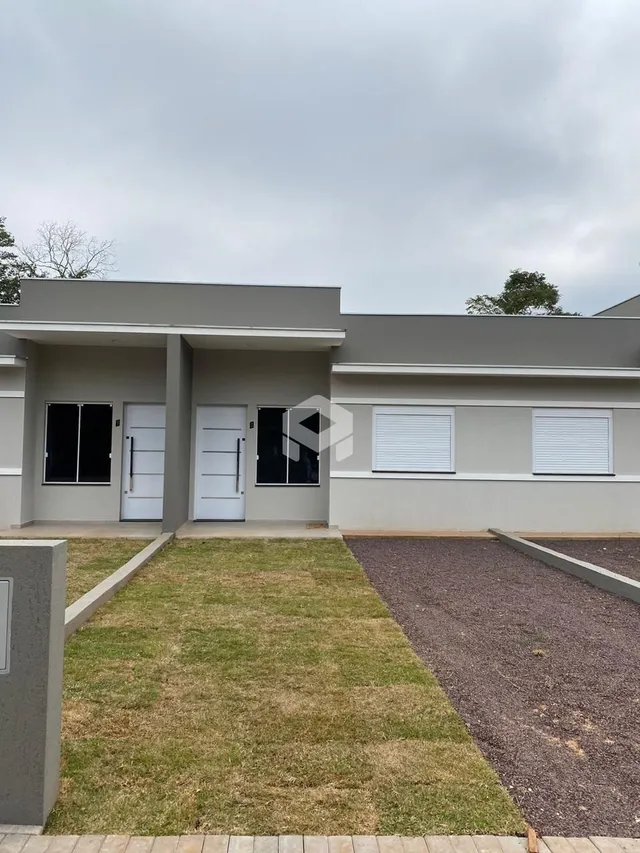 Fachada de uma residência em Lajeado, Brasil, com jardim e área pavimentada.