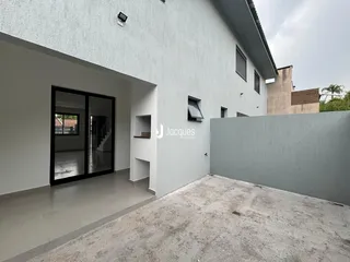 Fachada de uma residência branca com entrada de vidro em Lajeado, Brasil.