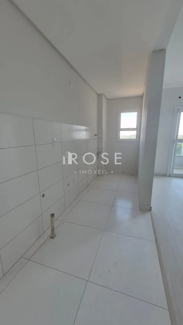 Corredor interno com piso de cerâmica branca em uma propriedade.