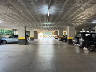 Foto de uma área de estacionamento coberta com veículos.