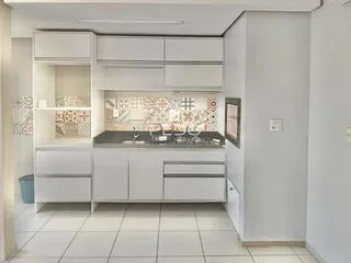 Cozinha moderna com armários brancos e revestimento de azulejos.