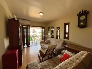 Sala de estar com piso de madeira e vista para o exterior.