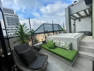 Vista de uma varanda com uma banheira externa e paisagem.