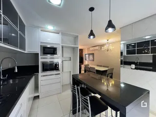 Cozinha moderna com ilha e mesa de jantar em um apartamento.