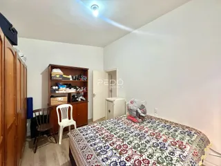 Quarto com cama e armário de madeira no interior da residência.