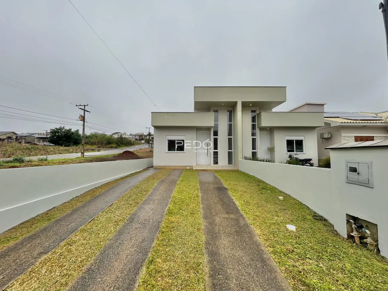 Fachada de uma casa moderna em Lajeado, Brasil, com jardim e calçada.