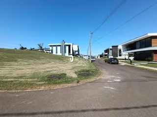 Vista externa de residências em Lajeado, Brasil, com área gramada e estrada.