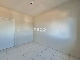Interior de uma sala com piso de cerâmica e parede branca.