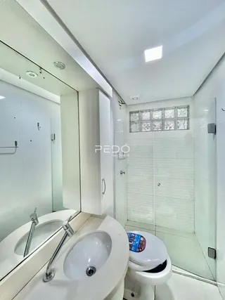 Foto do interior de um banheiro com revestimento cerâmico branco.