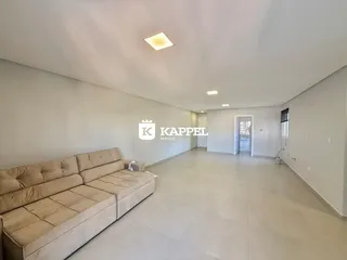 Esta é uma sala ampla com um sofá e piso claro.