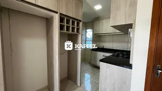 Uma cozinha moderna com armários de madeira e bancada escura.