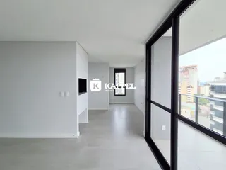 Hall de corredor com piso claro e grande janela para a vista urbana.