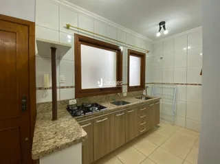 Uma cozinha com armários de madeira e bancadas de granito.