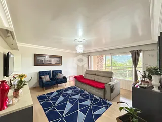 Sala de estar com sofá e tapete em um apartamento no Brasil.