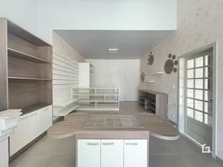 Interior de uma sala de estar com móveis de madeira e armários brancos.