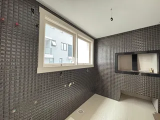 Parede com revestimento escuro e janela no interior da propriedade.