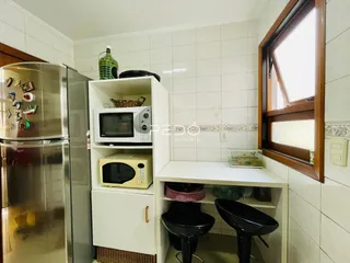Foto de uma cozinha com armários brancos e eletrodomésticos de aço inoxidável.