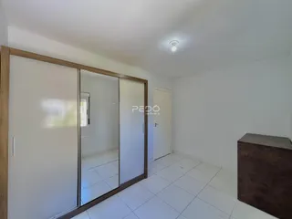 Um corredor interno com portas de vidro e piso de cerâmica.