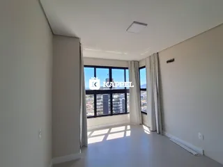 Sala de estar com grandes janelas que proporcionam vista para a paisagem externa.