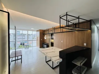 Ambiente moderno de sala de estar com piso de cerâmica e ilha de mármore em Lajeado.