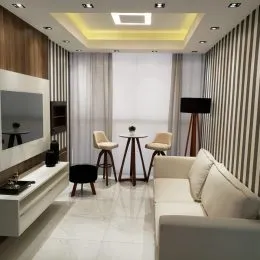 Sala de estar moderna com sofá e iluminação clara.