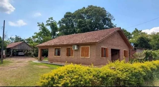 Fachada de uma casa de madeira com telhado inclinado e gramado à frente em Lajeado, Brasil.