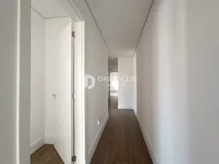 Corredor interno de uma residência com piso de madeira.