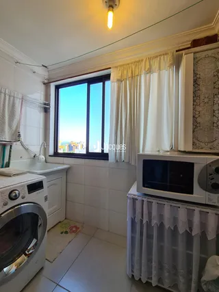 Interior de uma área de serviço com janela para a vista da cidade.