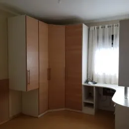 Ambiente interno com armários em madeira e piso claro.