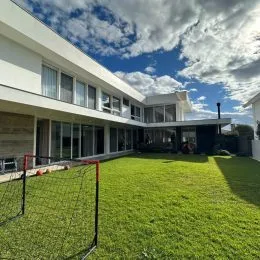 Área externa com gramado verde e cerca na propriedade.