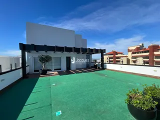 Vista da fachada de uma residência moderna com área externa verde.