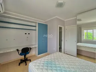 Quarto com cama e armário em ambiente claro.