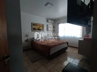 Quarto com cama de madeira e piso de cerâmica.