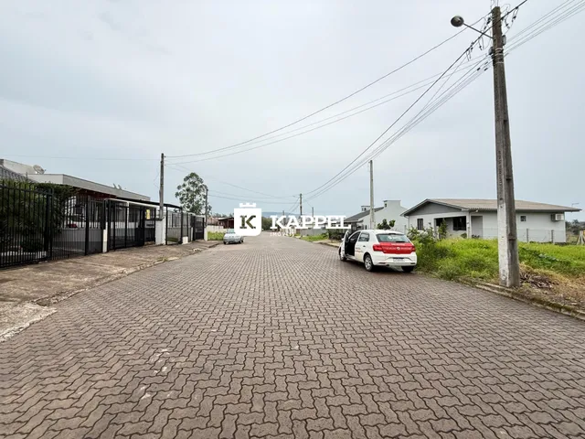 Vista da rua pavimentada em Lajeado, Brasil, com casas ao fundo.